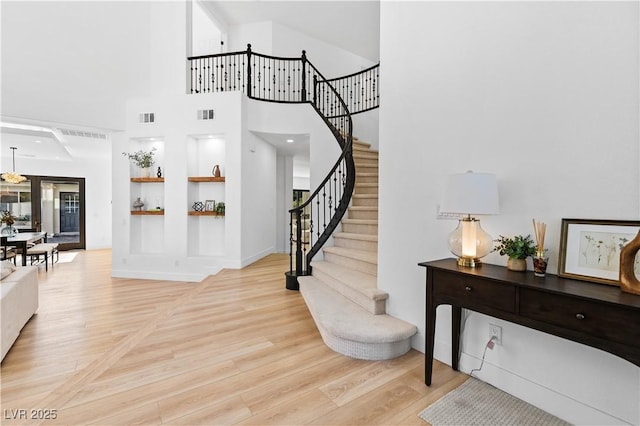 foyer entrance featuring a high ceiling and light hardwood / wood-style floors