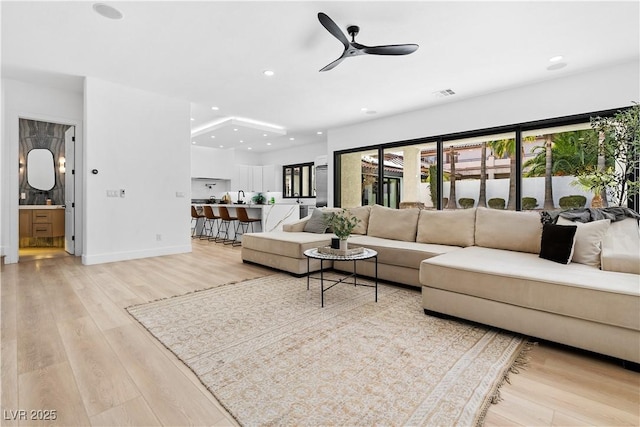 living room featuring light hardwood / wood-style floors and ceiling fan