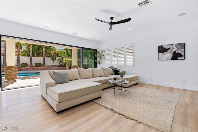 living room with ceiling fan and light hardwood / wood-style floors