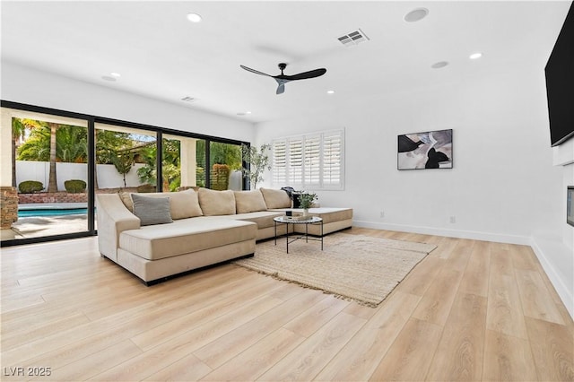 living room with light wood-type flooring and ceiling fan