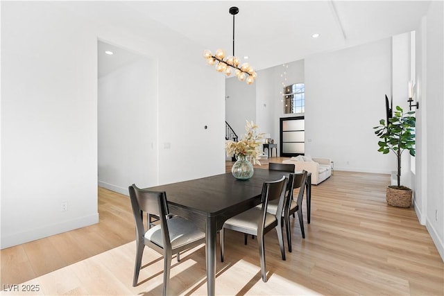 dining area featuring light hardwood / wood-style floors and an inviting chandelier