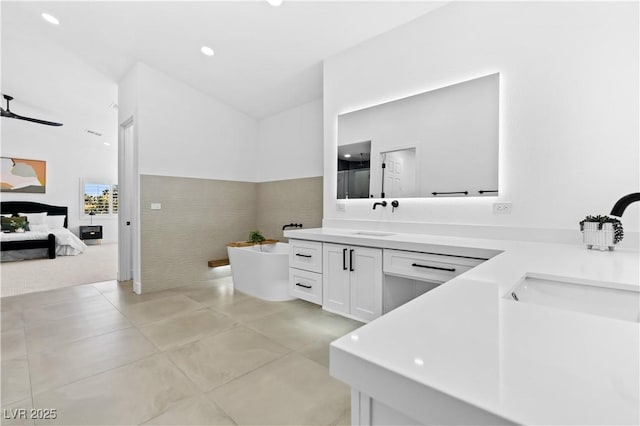 bathroom featuring vanity, ceiling fan, and a tub