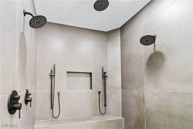 bathroom with a tile shower and a textured ceiling