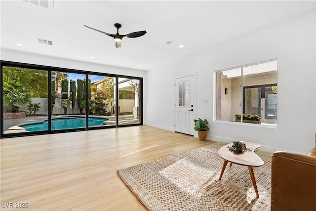 living room with ceiling fan and light hardwood / wood-style flooring