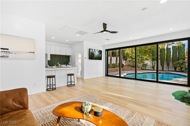 living room featuring light wood-type flooring and ceiling fan