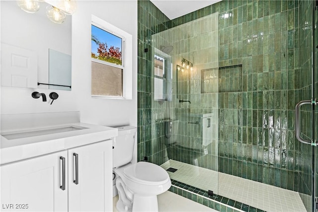 bathroom featuring vanity, toilet, and a shower with shower door