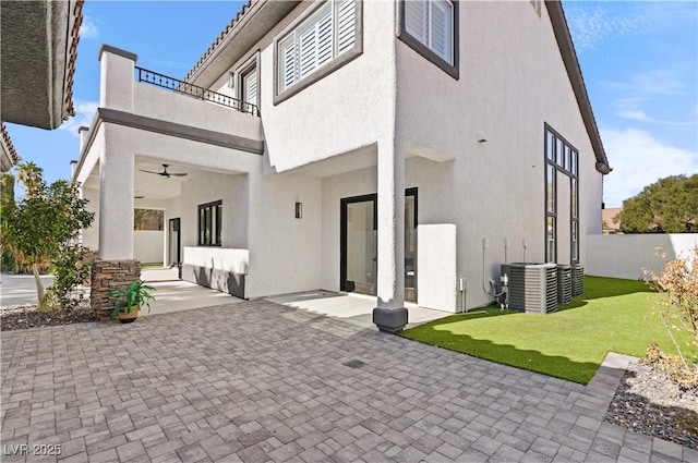 back of property featuring cooling unit, a balcony, and a patio