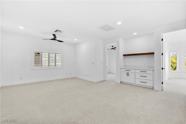 unfurnished living room with light carpet and ceiling fan