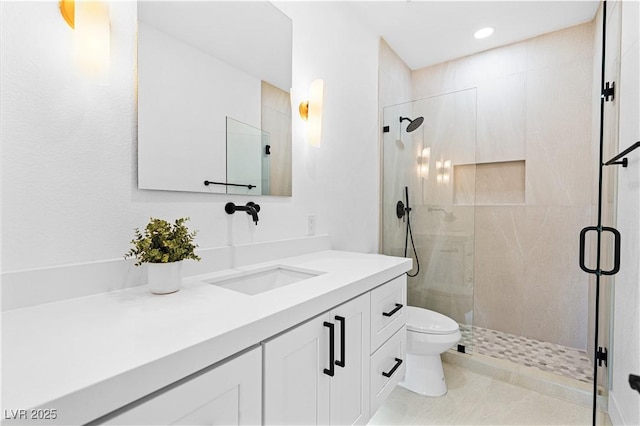 bathroom with vanity, toilet, and a shower with door