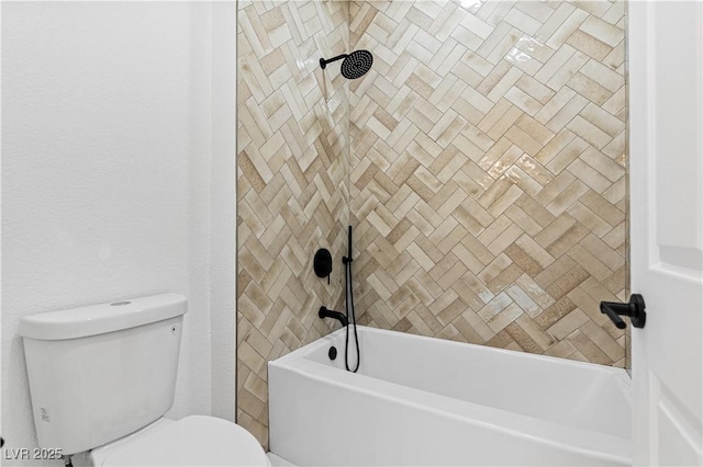 bathroom with tiled shower / bath combo and toilet