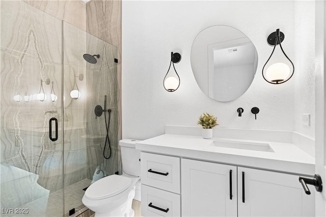 bathroom featuring vanity, toilet, and a shower with shower door