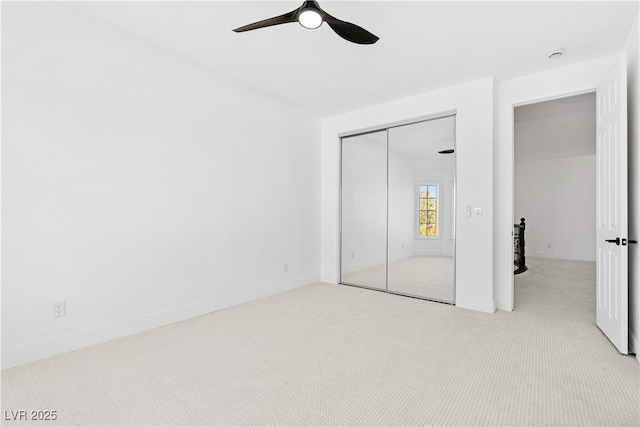 unfurnished bedroom with light carpet, a closet, and ceiling fan