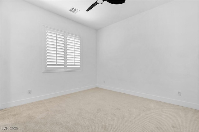 empty room featuring ceiling fan and light colored carpet