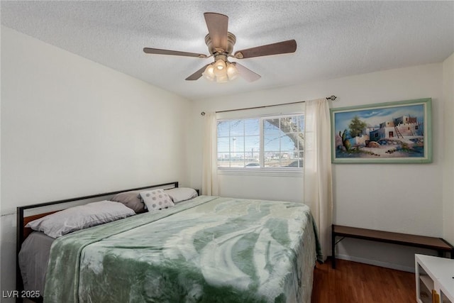 bedroom with ceiling fan, hardwood / wood-style floors, and a textured ceiling