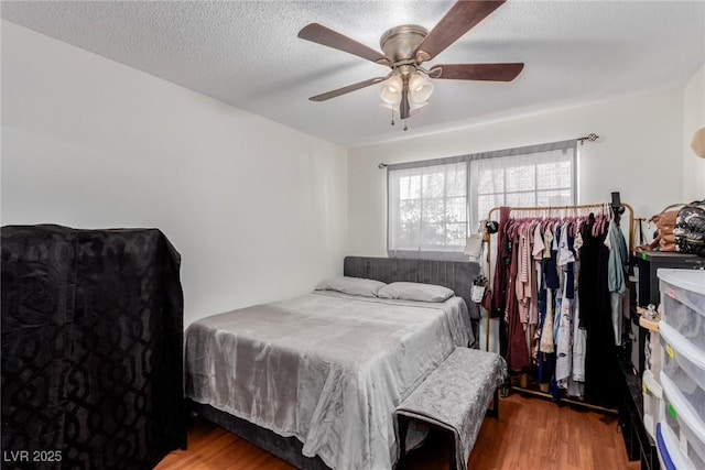 bedroom featuring hardwood / wood-style flooring, a textured ceiling, and ceiling fan