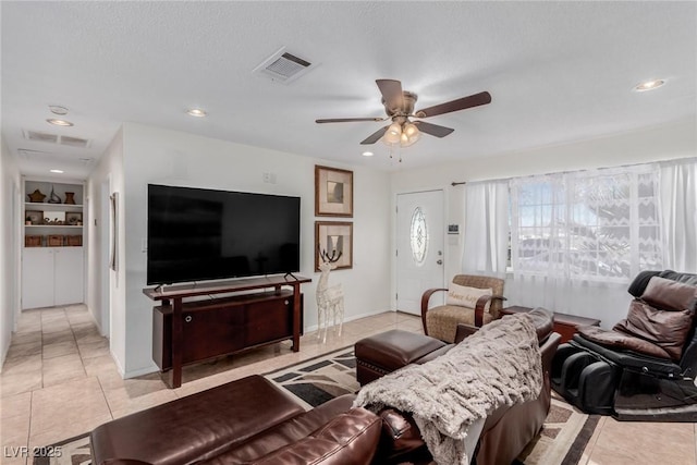 living room featuring ceiling fan, built in features, and light tile patterned floors