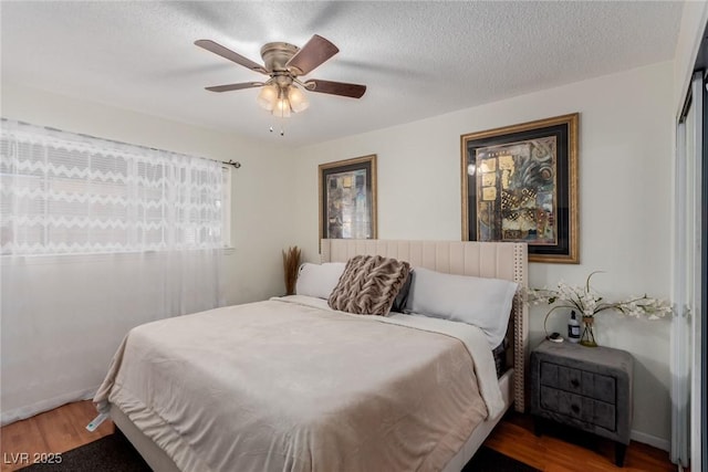 bedroom featuring ceiling fan, dark hardwood / wood-style floors, a closet, and a textured ceiling