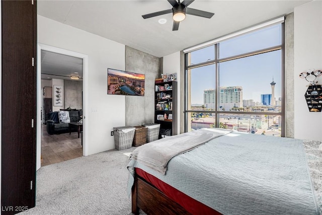 carpeted bedroom featuring ceiling fan and expansive windows