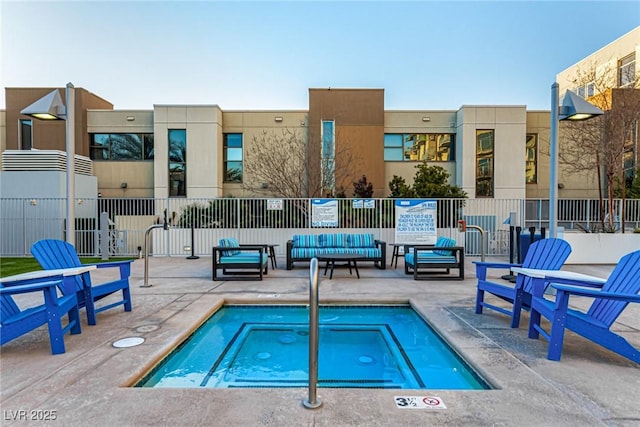 view of pool with fence, a community hot tub, and a patio