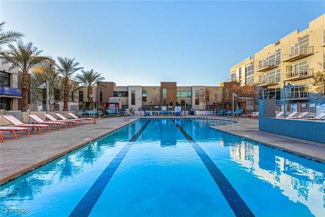 community pool featuring a patio area, a residential view, and fence