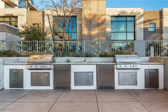 view of patio featuring an outdoor kitchen, grilling area, and a sink