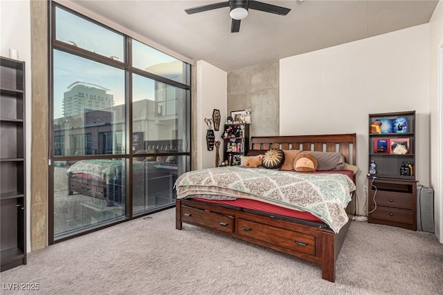 bedroom with ceiling fan, floor to ceiling windows, and light colored carpet