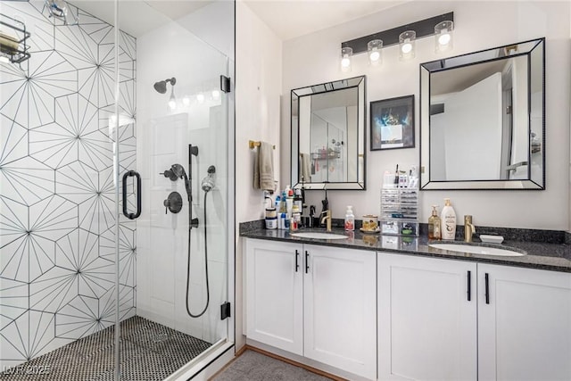 full bathroom featuring double vanity, a shower stall, and a sink