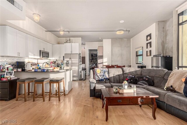 living room with sink and light hardwood / wood-style floors