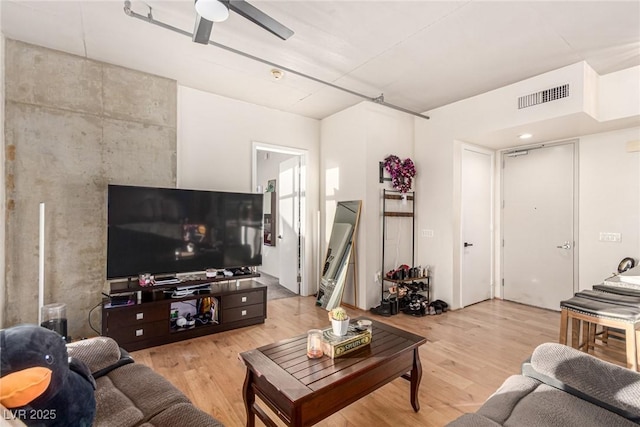 living room featuring ceiling fan, light wood-type flooring, and visible vents