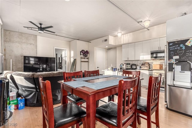 dining area featuring ceiling fan, light wood-type flooring, and visible vents