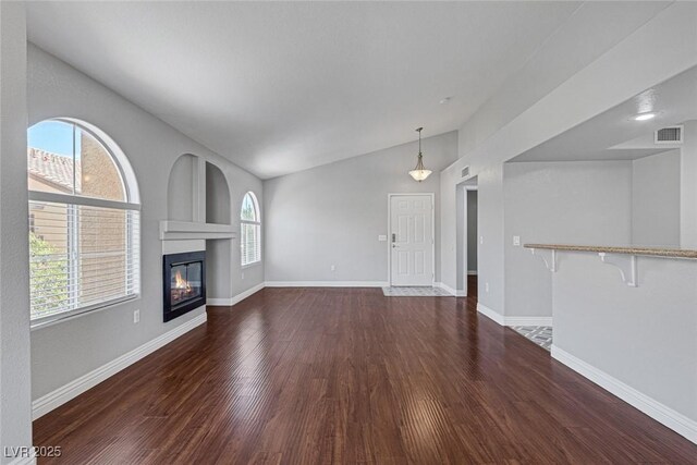 unfurnished living room with dark hardwood / wood-style floors and lofted ceiling