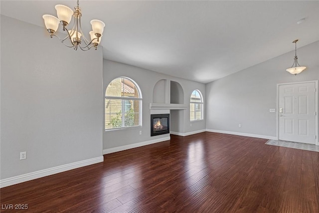 unfurnished living room with dark wood-type flooring, a chandelier, and lofted ceiling