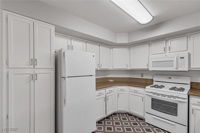 kitchen featuring white cabinets, white appliances, and a textured ceiling