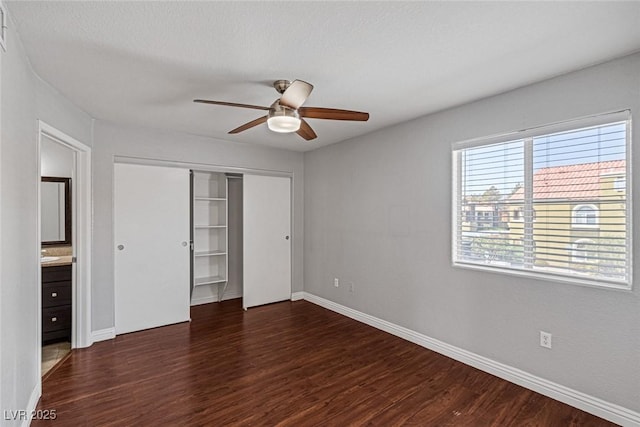 unfurnished bedroom featuring a closet, ceiling fan, and dark hardwood / wood-style flooring