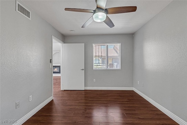 spare room with dark hardwood / wood-style floors and ceiling fan