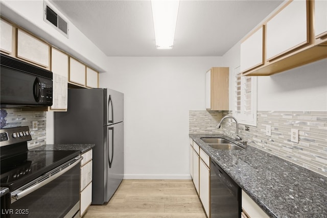 kitchen with dark stone counters, black appliances, sink, light hardwood / wood-style flooring, and white cabinetry