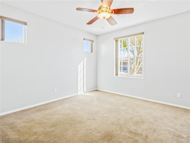 carpeted spare room featuring ceiling fan