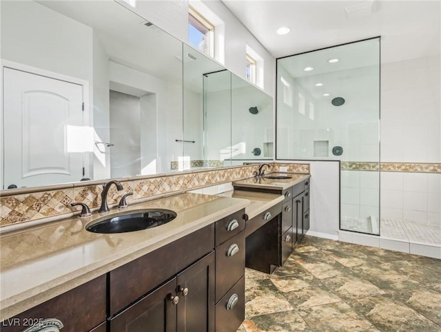 bathroom featuring vanity, a tile shower, and backsplash