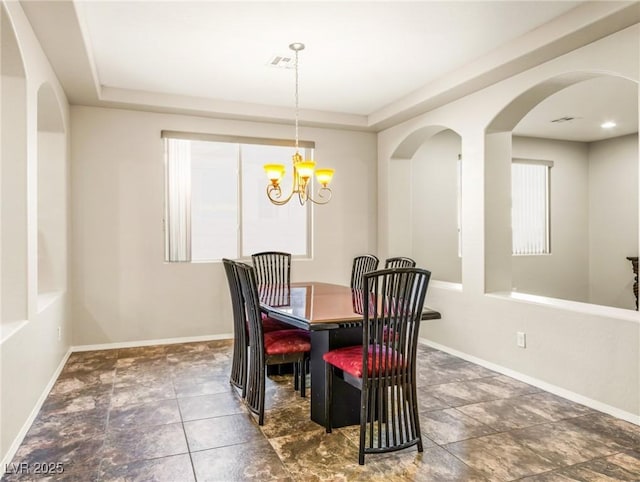 dining room featuring a tray ceiling and an inviting chandelier