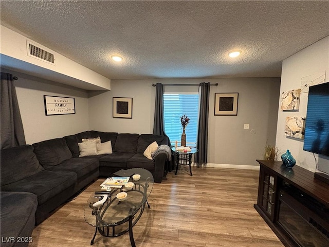 living room featuring a textured ceiling and light hardwood / wood-style flooring