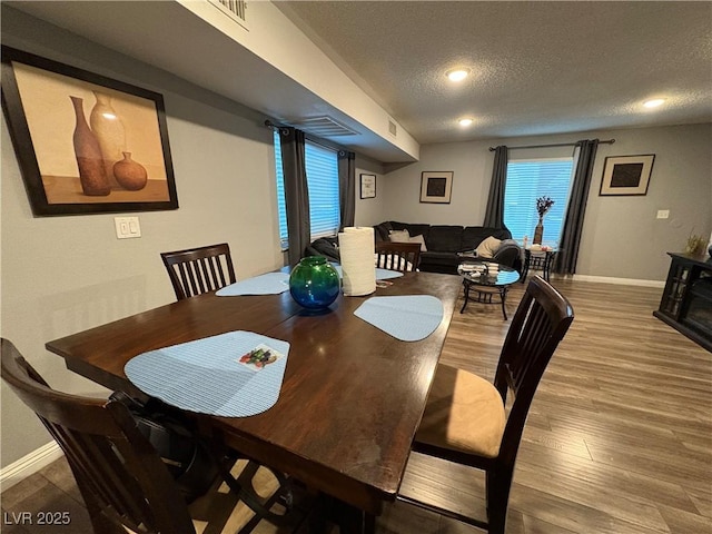 dining space with a textured ceiling and hardwood / wood-style floors