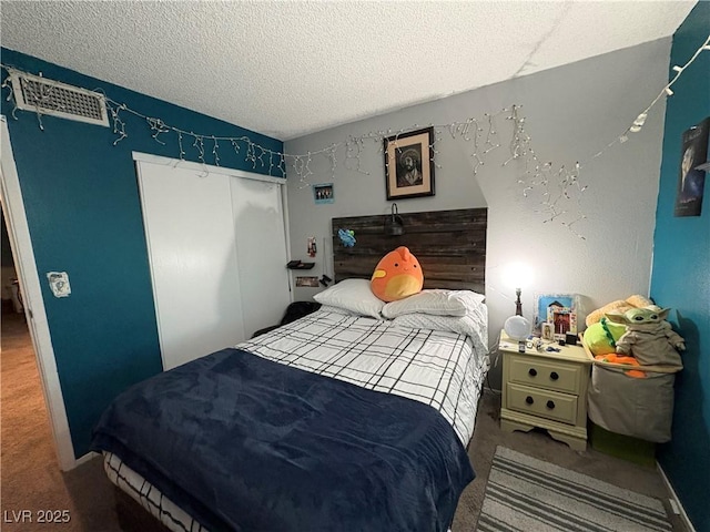 carpeted bedroom featuring a textured ceiling and a closet