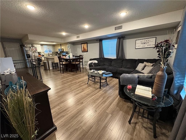 living room featuring a textured ceiling and hardwood / wood-style floors