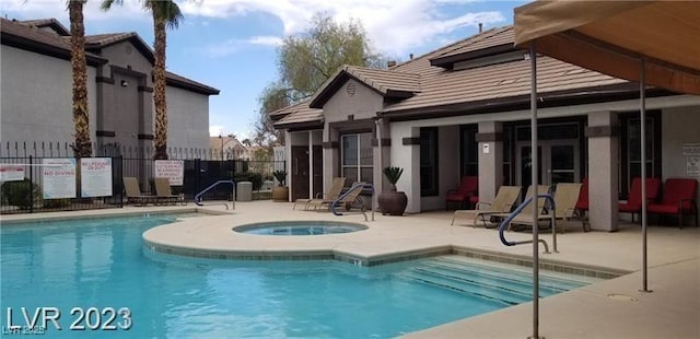 view of swimming pool featuring a community hot tub and a patio