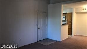 spare room with dark carpet