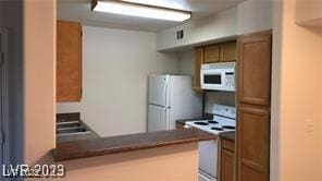 kitchen with kitchen peninsula and white appliances