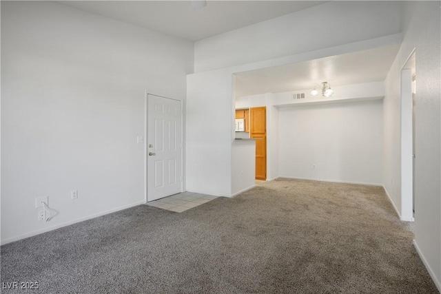empty room featuring visible vents, carpet, and baseboards