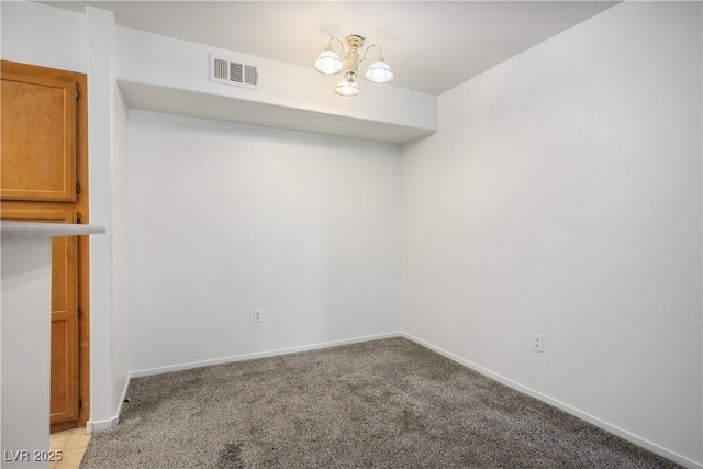 unfurnished dining area featuring visible vents, baseboards, a notable chandelier, and light carpet