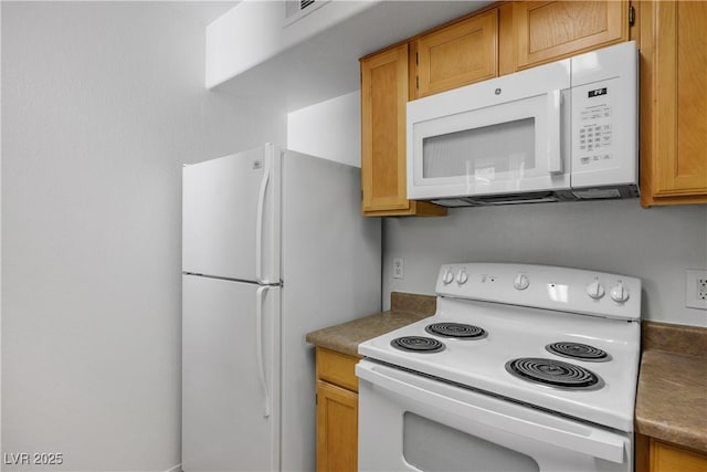 kitchen with white appliances, dark countertops, visible vents, and brown cabinetry