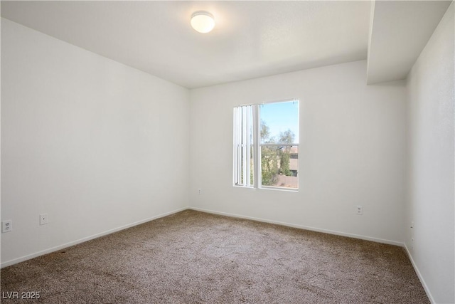 carpeted empty room featuring baseboards